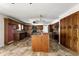Expansive kitchen featuring dark wooden cabinets, tile floors, island, and modern appliances and workspace at 1702 Miller S Rd, Valrico, FL 33594
