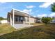 Backyard view featuring a covered patio, screened in porch, and green grass at 18314 Waydale Loop, Hudson, FL 34667