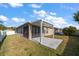 Backyard view featuring a covered patio, screened in porch, and green grass at 18314 Waydale Loop, Hudson, FL 34667