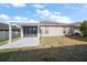 Backyard view featuring a covered patio, screened in porch, and green grass at 18314 Waydale Loop, Hudson, FL 34667