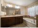 Bathroom with double sinks, garden tub, and separate walk-in shower at 18314 Waydale Loop, Hudson, FL 34667