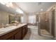 Bathroom featuring double sinks, a walk-in shower, and a soaking tub at 18314 Waydale Loop, Hudson, FL 34667