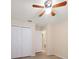 Bedroom with a ceiling fan, closet doors, and a doorway to another room at 18314 Waydale Loop, Hudson, FL 34667