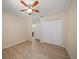 Bedroom featuring wood floors, closet, ceiling fan, and ensuite bathroom at 18314 Waydale Loop, Hudson, FL 34667