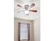 Bedroom showcasing a ceiling fan with wood blades and a window with lilac curtains at 18314 Waydale Loop, Hudson, FL 34667