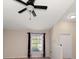 Bright living room featuring neutral walls, dark curtains, wood floors, and a ceiling fan at 18314 Waydale Loop, Hudson, FL 34667
