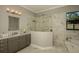 Elegant bathroom with marble floors, a glass walk-in shower and a soaking tub at 18483 Purple Creek Ln # Lot 1, Lutz, FL 33549