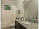 Clean bathroom with tub and shower, granite countertop, and a framed mirror at 18483 Purple Creek Ln # Lot 1, Lutz, FL 33549
