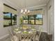 Cozy dining room featuring bright windows with backyard views and modern chandelier at 18483 Purple Creek Ln # Lot 1, Lutz, FL 33549