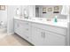 Bathroom boasts a double vanity, with white cabinetry and modern fixtures at 19195 Blue Pond Dr, Lutz, FL 33558
