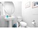 Well-lit powder room featuring a pedestal sink, modern fixtures, and neutral decor for a clean, minimalist aesthetic at 19195 Blue Pond Dr, Lutz, FL 33558