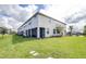 Exterior elevation showing a lawn, covered patio, and rear of the house at 19195 Blue Pond Dr, Lutz, FL 33558