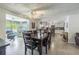 Open-concept dining room showcases a large wooden table, tile floors, and seamless flow into the living room and kitchen at 2051 Lyra Dr, Holiday, FL 34690