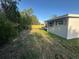 Backyard view with newly installed privacy fence, greenery, and view of the rear home exterior at 21042 Gladis Ave, Port Charlotte, FL 33952