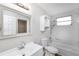 Bright bathroom with tile surround bathtub and shower combo, cabinet storage, and decorative mirror at 21042 Gladis Ave, Port Charlotte, FL 33952