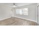 Sunny bedroom featuring updated plank floors, ceiling fan, and a bright window at 21042 Gladis Ave, Port Charlotte, FL 33952