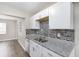 Updated kitchen featuring white cabinets, modern backsplash, stainless steel sink and granite countertops at 21042 Gladis Ave, Port Charlotte, FL 33952