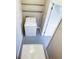 Compact laundry room features a washing machine, storage shelves, and access to another room at 21042 Gladis Ave, Port Charlotte, FL 33952