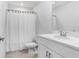 Well-lit bathroom featuring a white vanity, toilet, and shower with a white curtain at 2265 Alee Ln, Wesley Chapel, FL 33543