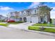 View of light-blue two-story townhomes, showing well-manicured lawns and neat driveways at 2265 Alee Ln, Wesley Chapel, FL 33543
