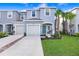 Charming two-story townhome with a one-car garage, blue front door, and well-maintained landscaping at 2265 Alee Ln, Wesley Chapel, FL 33543