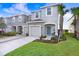 Charming two-story townhome with a one-car garage, blue front door, and well-maintained landscaping at 2265 Alee Ln, Wesley Chapel, FL 33543