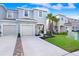 Charming two-story townhome with a one-car garage, blue front door, and well-maintained landscaping at 2265 Alee Ln, Wesley Chapel, FL 33543