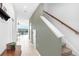 Bright hallway with staircase showcasing neutral colors, tiled floors, and access to waterfront views at 2265 Alee Ln, Wesley Chapel, FL 33543
