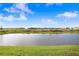 Scenic view of a tranquil pond surrounded by lush greenery and a bright blue sky at 2265 Alee Ln, Wesley Chapel, FL 33543