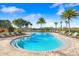 Beautiful community pool surrounded by palm trees and lounge chairs at 2265 Alee Ln, Wesley Chapel, FL 33543