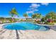 Community pool surrounded by palm trees and lounge chairs at 2265 Alee Ln, Wesley Chapel, FL 33543