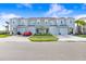 Street view of modern light-blue townhomes, showcasing driveways, lawns, and simple landscaping at 2265 Alee Ln, Wesley Chapel, FL 33543
