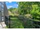 Lush backyard featuring a black metal fence and mature trees offering a private outdoor space at 2835 Hilliard Dr, Wesley Chapel, FL 33543