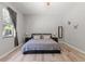 Serene bedroom with neutral tones, wood floors, large window, and stylish decor at 2835 Hilliard Dr, Wesley Chapel, FL 33543