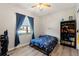 Cozy bedroom featuring a ceiling fan, window with blue curtains and a bookcase with books and toys at 2835 Hilliard Dr, Wesley Chapel, FL 33543