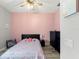 Charming bedroom with a pink wall, ceiling fan, a black dresser and wood-style flooring at 2835 Hilliard Dr, Wesley Chapel, FL 33543