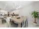 Open-concept kitchen and dining area with modern lighting, white cabinetry, and stainless appliances at 2835 Hilliard Dr, Wesley Chapel, FL 33543
