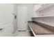 Functional laundry room with granite counters, storage, and convenient access at 2835 Hilliard Dr, Wesley Chapel, FL 33543