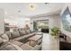 Open concept living room with a large sectional, kitchen, and view of the screened-in pool at 2835 Hilliard Dr, Wesley Chapel, FL 33543