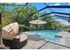 Resort-style screened-in pool with a covered seating area, lounge chair, and mature landscaping at 2835 Hilliard Dr, Wesley Chapel, FL 33543