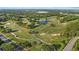 Aerial view of a golf course with manicured greens, water hazards, and scenic views at 2969 Talon Dr, Clearwater, FL 33761