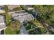 Aerial view of a home with a screened pool, mature trees, and a well-kept lawn at 2969 Talon Dr, Clearwater, FL 33761