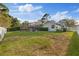 Expansive backyard with a lush green lawn, screened pool enclosure, and mature landscaping, offering privacy and space at 2969 Talon Dr, Clearwater, FL 33761