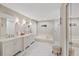 Bright bathroom with tile flooring, double vanity, soaking tub and glass enclosed shower at 2969 Talon Dr, Clearwater, FL 33761