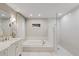 Bright bathroom featuring tile flooring, soaking tub, and glass-enclosed shower; features recessed lighting at 2969 Talon Dr, Clearwater, FL 33761