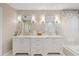 Bright bathroom featuring tiled flooring and double vanities; soaking tub and shower partially visible at 2969 Talon Dr, Clearwater, FL 33761