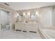 Bright bathroom featuring a double sink vanity with marble counters and a soaking tub with natural light at 2969 Talon Dr, Clearwater, FL 33761