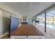 Spacious screened patio with brick flooring, a ping pong table, an outdoor kitchen, and a view of the sparkling pool at 2969 Talon Dr, Clearwater, FL 33761