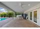 Large screened patio with brick flooring, ceiling fans, an outdoor ping pong table, and access to the pool area at 2969 Talon Dr, Clearwater, FL 33761