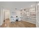 Bright home office featuring a built-in bookcase, white desk, and light wood flooring at 2969 Talon Dr, Clearwater, FL 33761
